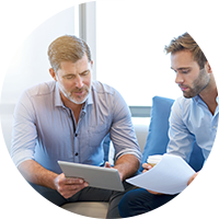 Two men looking at a tablet.