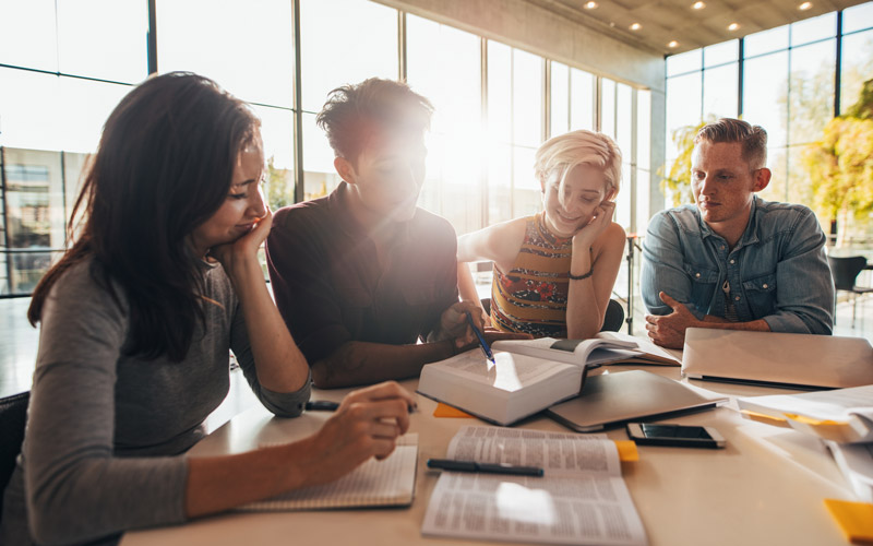 Students sitting around a desk studying