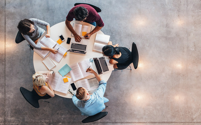 students working from table top view