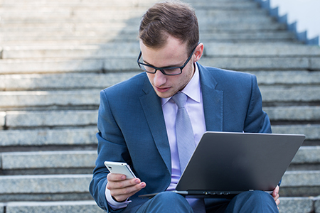 Businessman working on Laptop and iPhone