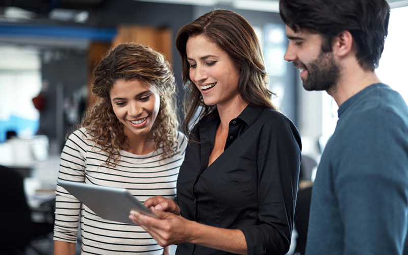 Colleagues gather around tablet device