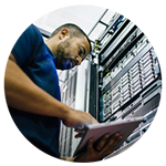 IT service technician typing on table in server room.
