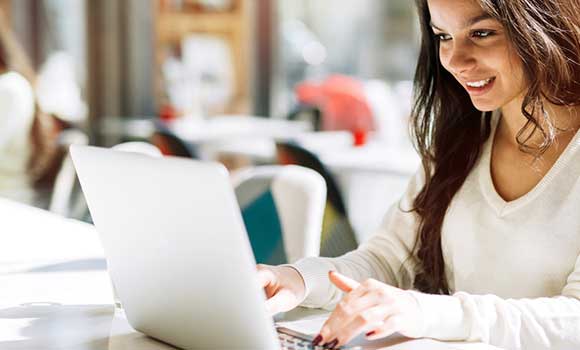 Female with smile working on laptop