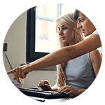 Two business women, on pointing to the montor