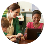Teacher working with school children working on a laptop
