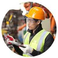Male factory worker reviews issues on tablet device