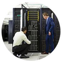 Two men working together on a server in a server room