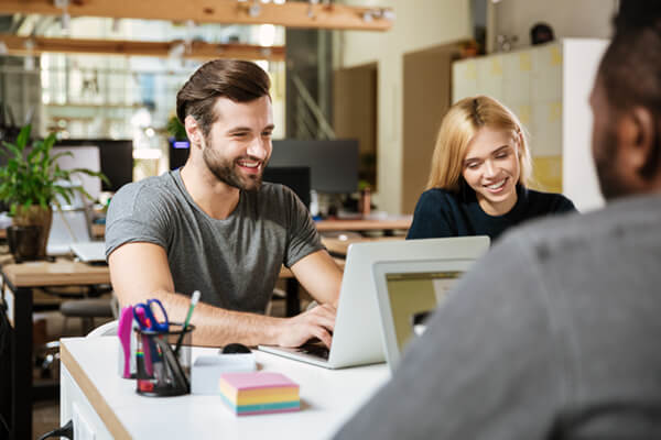 Business professionals in office with computer and tablets
