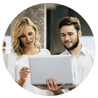 Two business professionals on laptop discussing cloud migration strategy