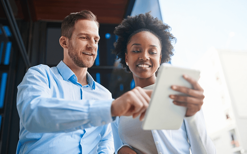 Two business professionals on tablet outside