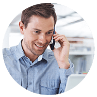 Smiling businessman uses mobile device and laptop to find tools and resources