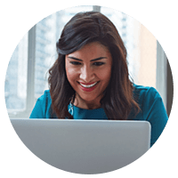 Smiling woman uses laptop computer in a modern workplace