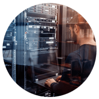 Man working on laptop in data center