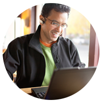 Man in public place talking on laptop.