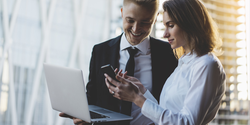 Business man and woman discussing content on smart phone