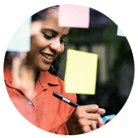 Business professional writing ideas on sticky-notes and putting up to wall
