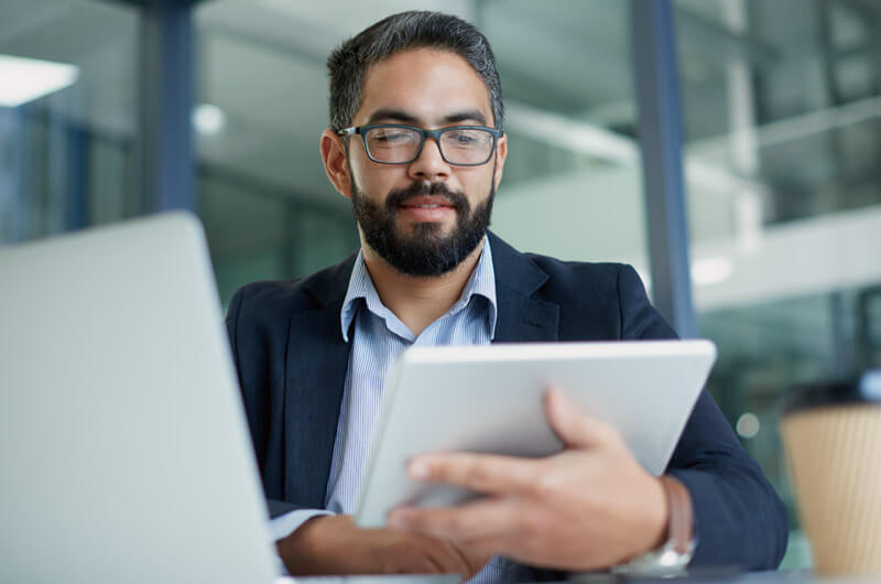 Business professional using multiple devices in the workplace