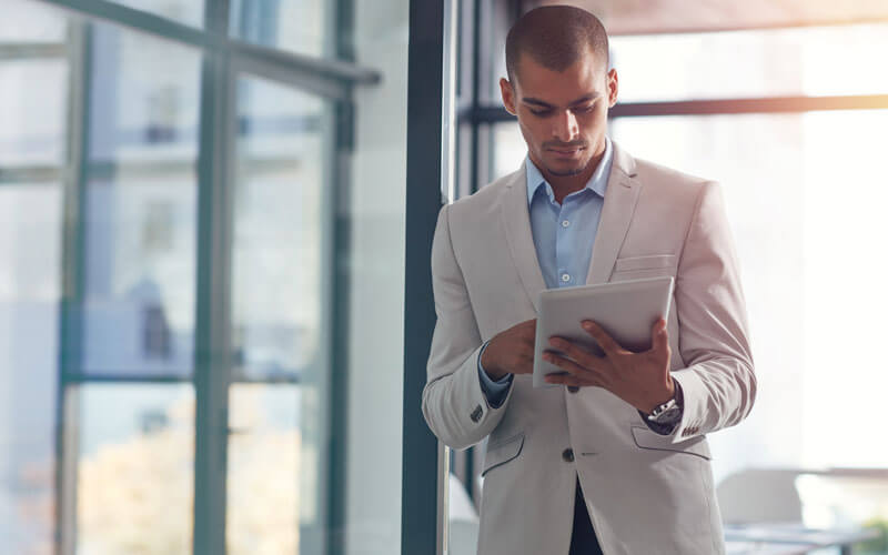 Businessman walking with tablet device
