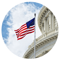 Worms eye view of federal building with raised flag.