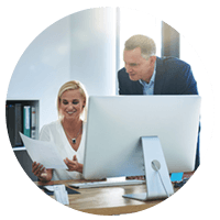 Business professionals look over licenses on desktop computer