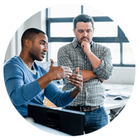 Two standing businessmen discuss workflow