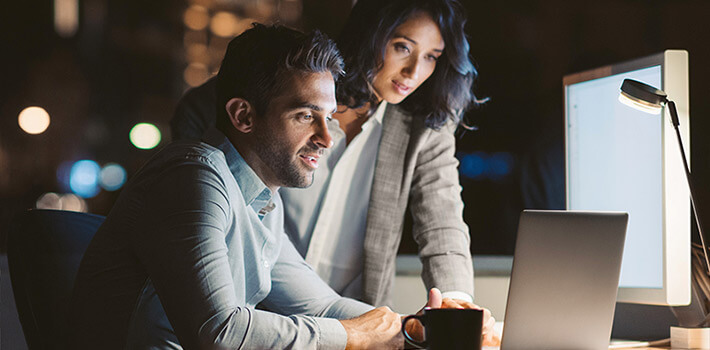 Coworkers collaborating around desktop computer