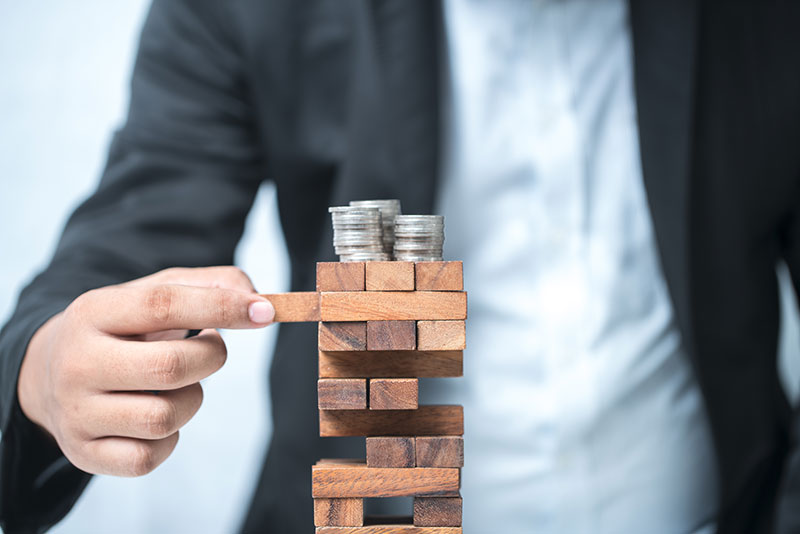 Man balancing money of a trembling tower