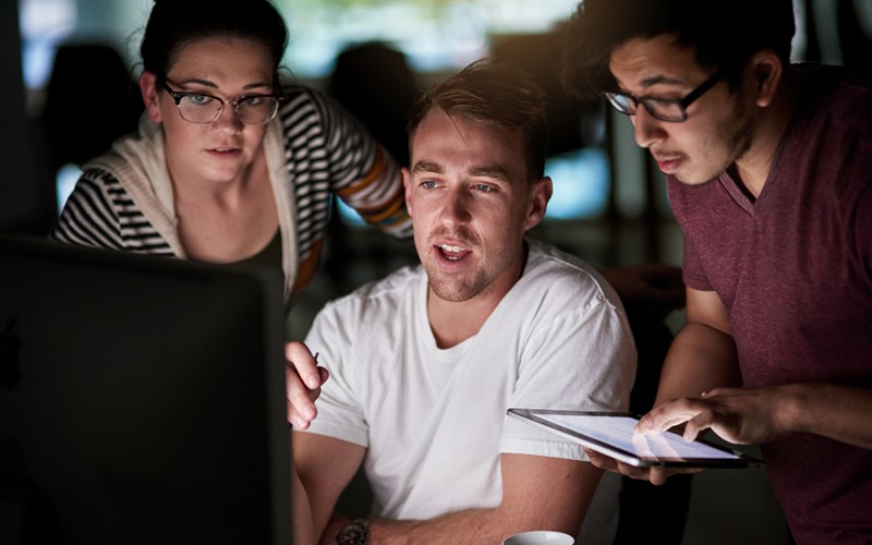 We work with you to develop a roadmap Group of colleagues working on cloud security with tablet device and computer