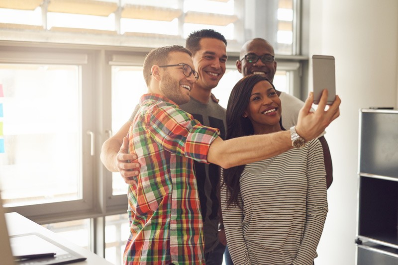 Understand customer sentiment. Group of entrepeneurs taking a selfie in the office.
