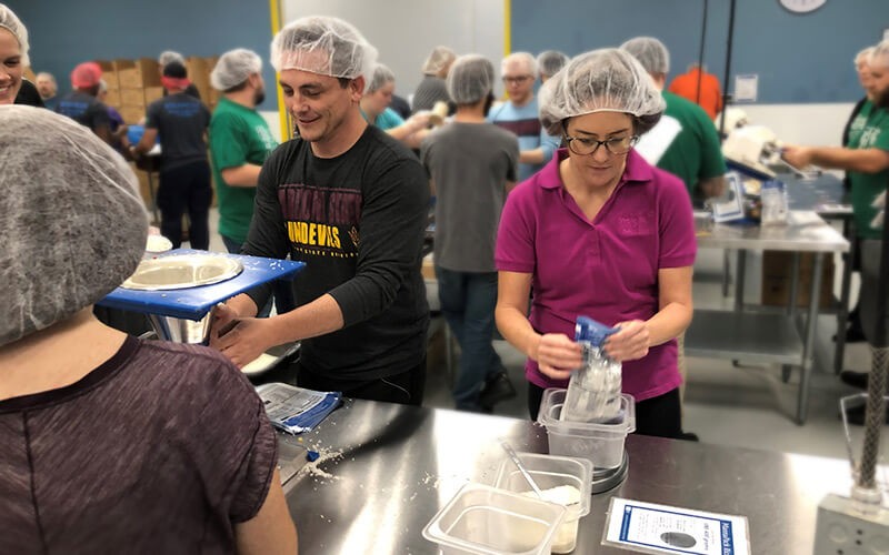 We work together to support local children, families, schools and charitable initiatives Insight teammates participate in packing food for Feed the Starving Children non-profit