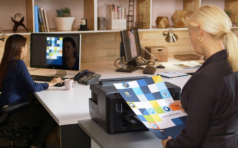Business woman in office grabbing print design from printer