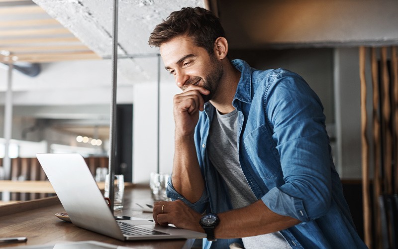 man thinking while using laptop