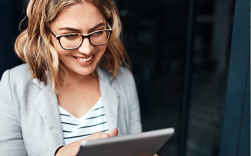 Drive business outcomes Smiling business woman on tablet outside