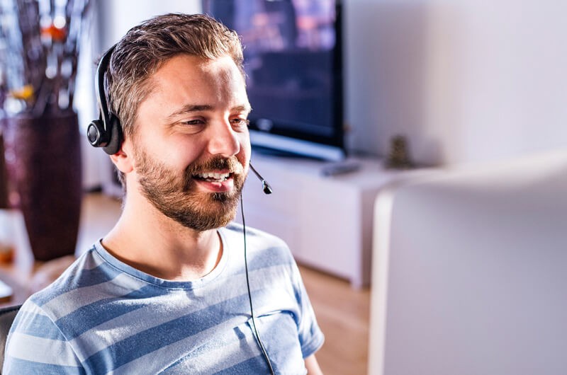 Enable your teams to work when, where and how they work best Male business professional talks with team from home office using remote collaboration tools