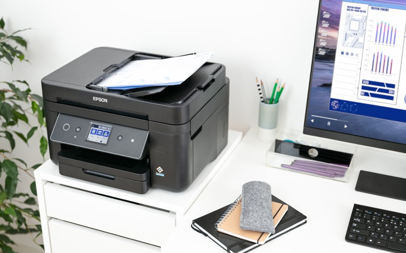Epson printers to solve even your most industry-specific printing challenges Woman working at Epson printer in open office