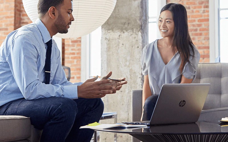 Two colleagues using a HP notebook in a meeting