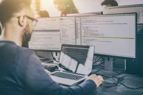 Protecting businesses against email attacks Male using multiple screens to work on business data