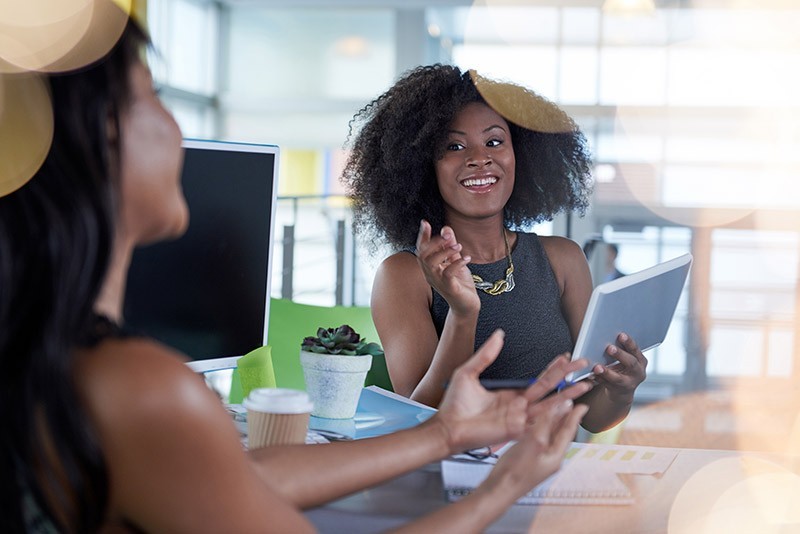 Two woman discussing over technology