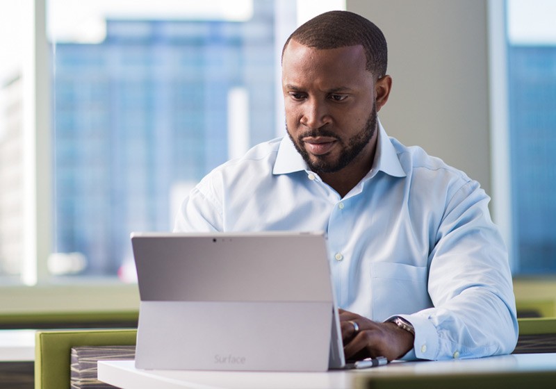 Cloud App Security Business manager reviewing applications off of his Surface Pro mobile tablet device