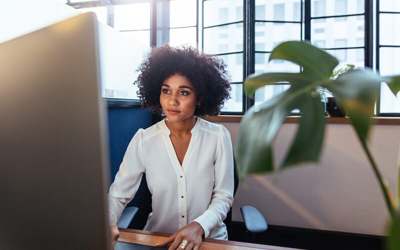 Move faster, create better experiences and minimize friction Businesswoman on desktop computer in office