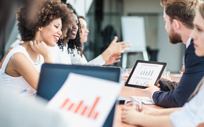 Stay out of the weeds with technology solutions Smiling analysts gather together with reports and data