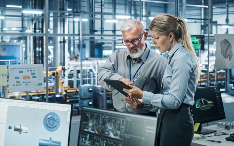 We ensure system and data security Two engineers use tablet device to look over manufacturing data