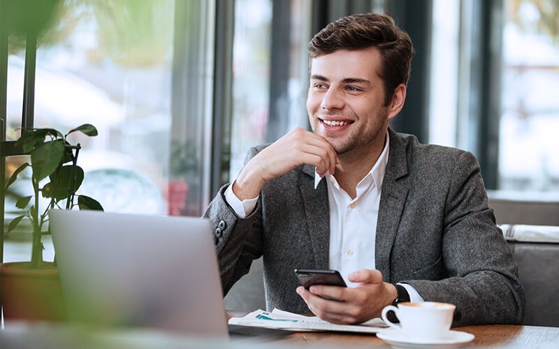Professional using mobile and laptop