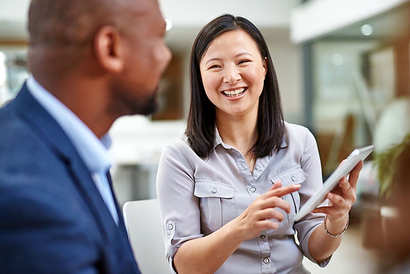 We’re committed to accountability, transparency and sustainability. Smiling business professional on tablet computer with client