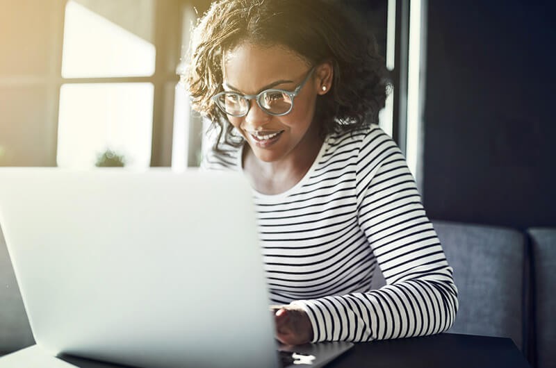 Smiling remote businesswoman on laptop computer
