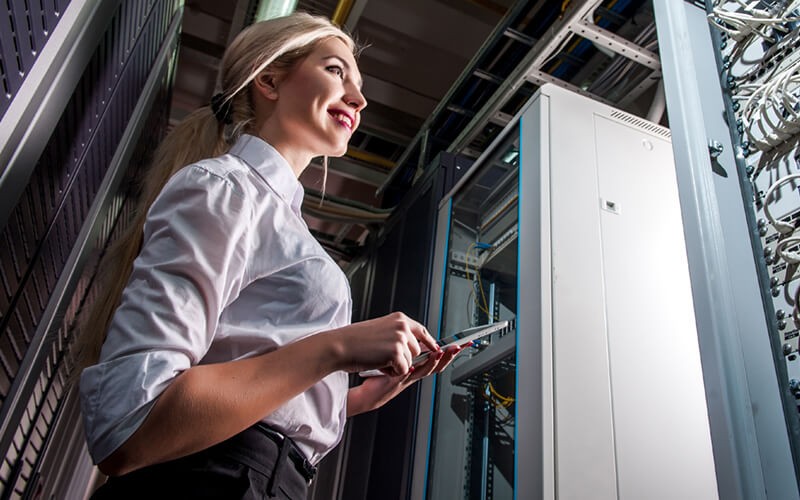 IT technician in server room with tablet