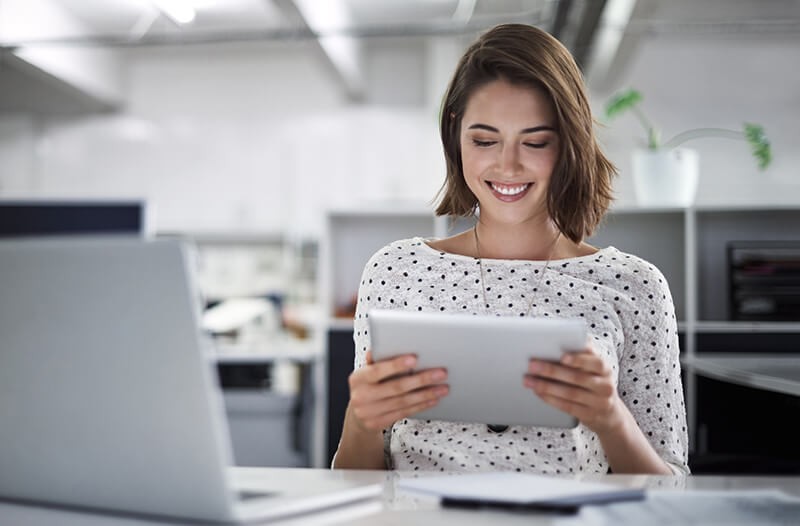 Business professional reading whitepaper off of tablet computer