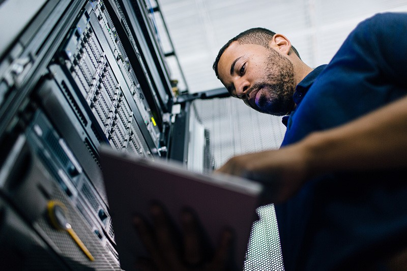 IT professional in data center on tablet device