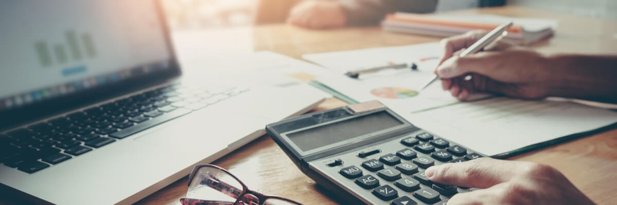 Accountant using calculator and looking at pie chart