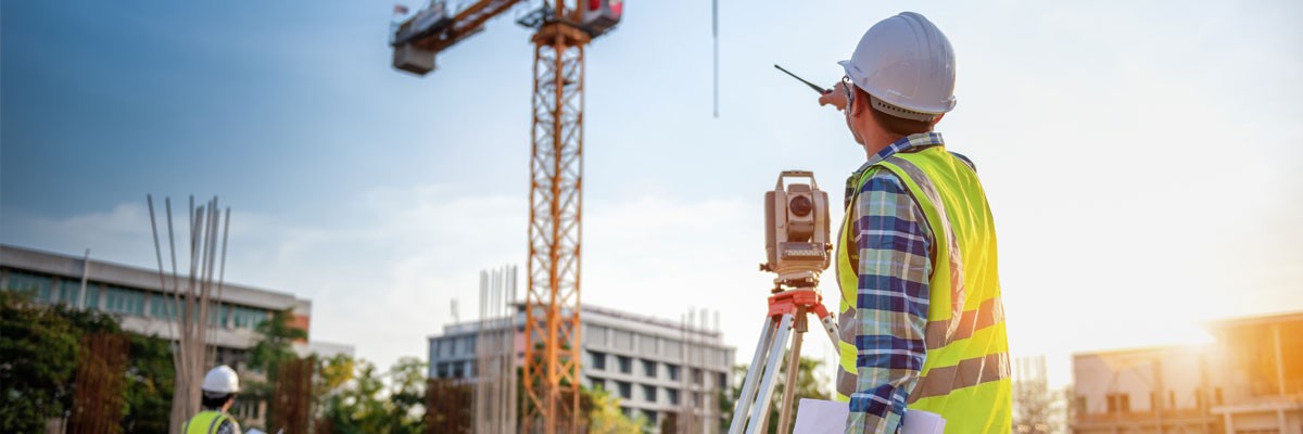 Two engineers at construction site setting up machinery